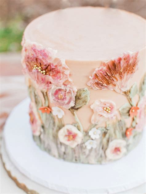 a tropical bridal shower cake with a gold tier, a white tier with greenery, blooms and greenery. a tropical bridal shower cake with leaves, stripes, a gilded sugar pineapple and a pink rose. We’re getting closer to the summer season, which is the best for a tropical wedding theme to shine. Lets rock a bridal shower in this theme.